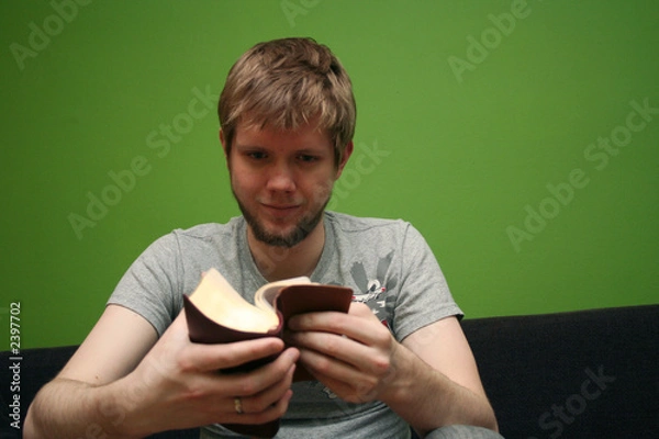 Obraz young man reading small bible