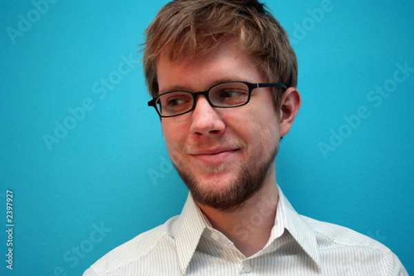 Obraz young man smiling against blue wall