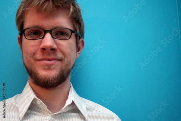 Obraz young man smiling against blue wall