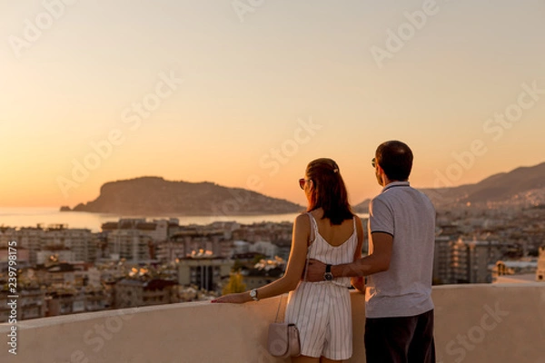 Obraz Young couple watching sunset from the rooftop terrace