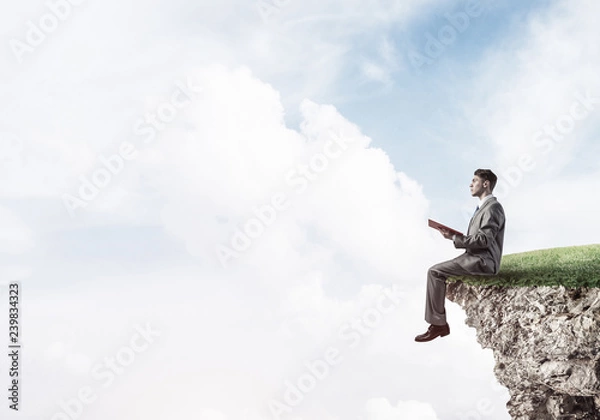 Fototapeta Student guy in suit with book in hands preparing for exam