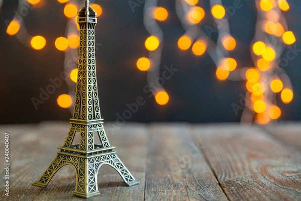 Obraz figurine of the Eiffel tower on a background garlands
