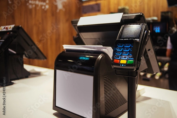 Fototapeta Point of sell terminal with touchless technology and cashbox on background