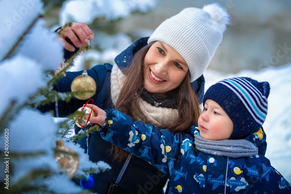 Obraz Christmas. Woman and child in winter in nature. Portrait of a happy family