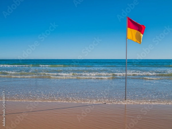 Obraz Beach with red and yellow flag indicating safe, patrolled beach in Australia