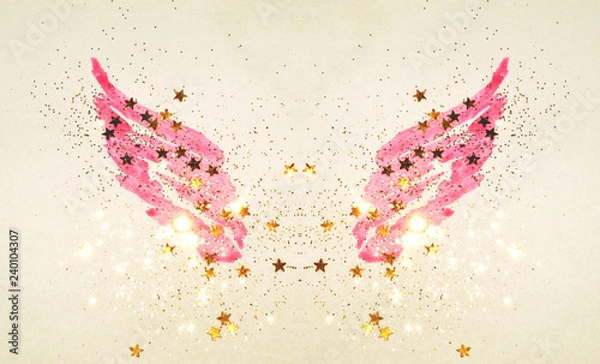 Fototapeta Golden glitter and glittering stars on abstract pink watercolor wings in vintage nostalgic colors.