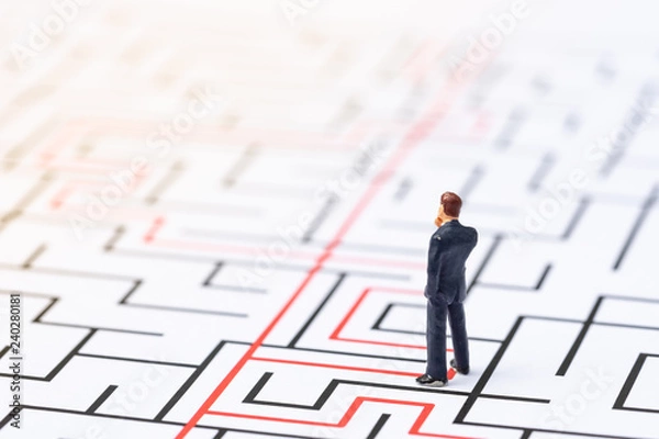Fototapeta Miniature people, businessman in the labyrinth or maze figuring out the way out. Business concept, finding solution, strategic, and business opportunity.