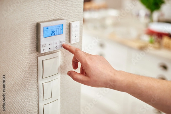 Obraz hand adjusting temperature inside house