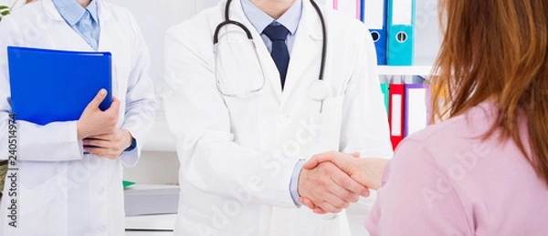 Obraz lekarz pozuje w biurze z personelem medycznym, ma na sobie stetoskop