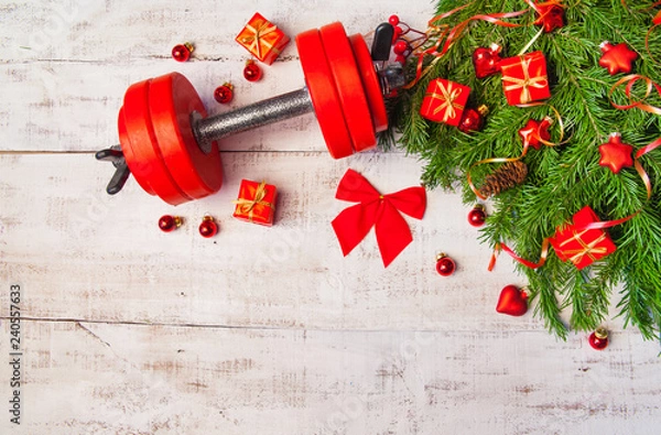 Obraz Christmas or New Year on a white background. Composition with dumbbells, gift, red and gold glass balls, fir tree branches for healthy lifestyle and sport