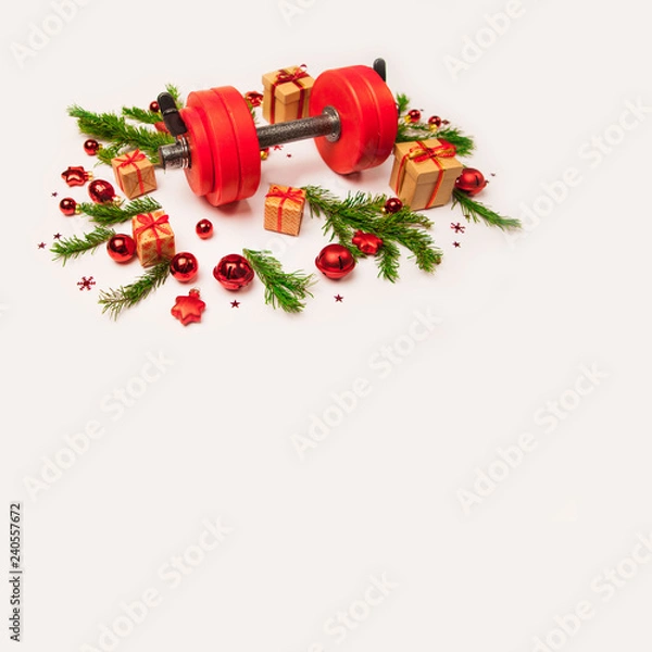 Obraz Christmas or New Year on a white background. Composition with dumbbells, gift, red and gold glass balls, fir tree branches for healthy lifestyle and sport