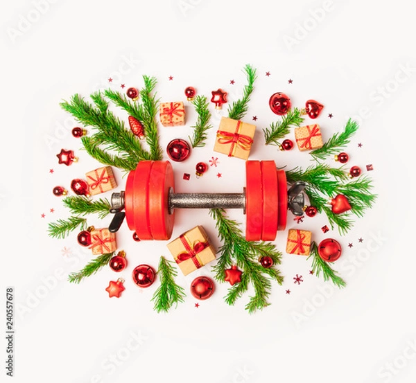 Obraz Christmas or New Year on a white background. Composition with dumbbells, gift, red and gold glass balls, fir tree branches for healthy lifestyle and sport