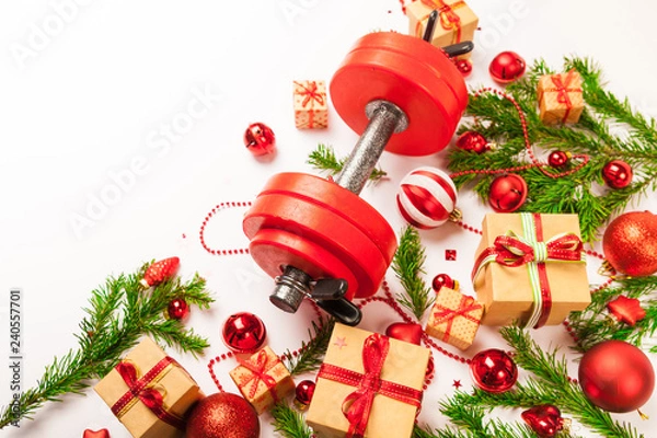 Obraz Christmas or New Year on a white background. Composition with dumbbells, gift, red and gold glass balls, fir tree branches for healthy lifestyle and sport