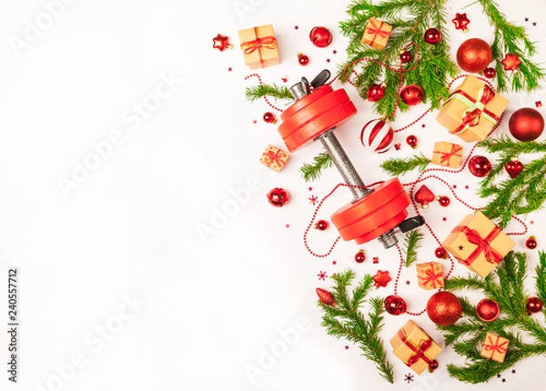 Obraz Christmas or New Year on a white background. Composition with dumbbells, gift, red and gold glass balls, fir tree branches for healthy lifestyle and sport
