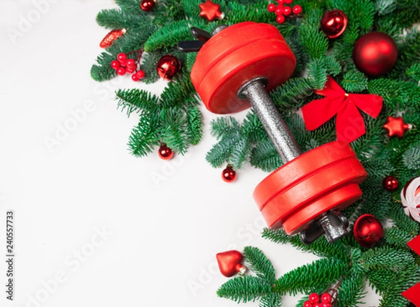 Obraz Christmas or New Year on a white background. Composition with dumbbells, gift, red and gold glass balls, fir tree branches for healthy lifestyle and sport