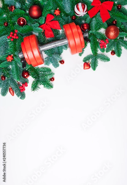 Obraz Christmas or New Year on a white background. Composition with dumbbells, gift, red and gold glass balls, fir tree branches for healthy lifestyle and sport