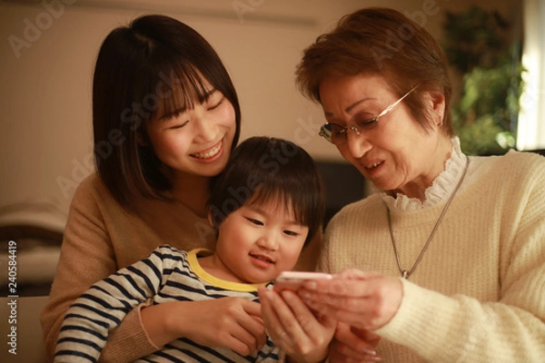 Obraz スマートフォンを見る家族