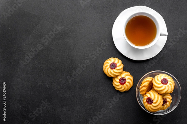 Obraz Dessert for evening tea. Cup of tea, fresh homemade cookies on black background top view space for text