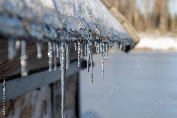 Obraz some icicles hanging at the gutter under the roof in winter