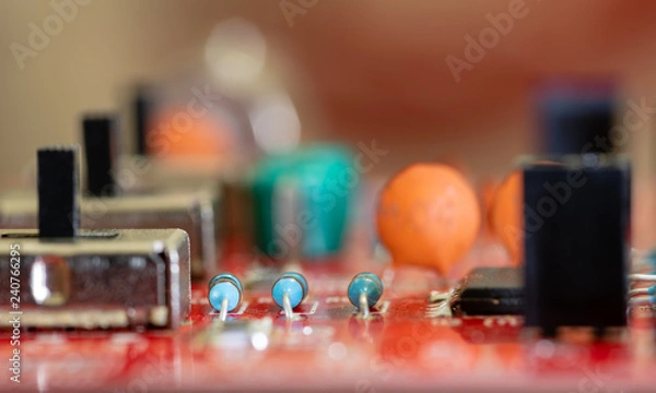 Fototapeta Close up (Macro) of Printed Circuit Board PCB embedded components (inductors, resistors, capacitors, diodes, microchips, transistor) with short depth of view