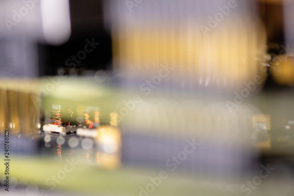 Fototapeta Close up (Macro) of Printed Circuit Board PCB embedded components (inductors, resistors, capacitors, diodes, microchips, transistor) with short depth of view.