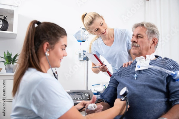Obraz zwei Krankenschwestern pflegen einen intensiv wachkoma Patienten im Krankenhaus oder Pflegeheim auf 
