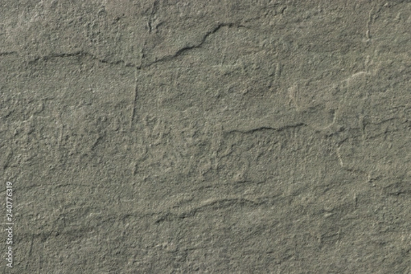 Fototapeta The texture of a dark gray stone with a rough and matte surface. Grunge background with space for text or image. Grey backdrop.