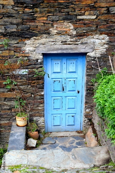 Obraz Rustic hand-hewn wood door set into a stone wall built from schist in Piodão, made of shale rocks stack, one of Portugal's schist villages in the Aldeias do Xisto.