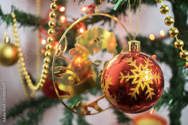 Obraz Closeup of red bauble hanging from a decorated Christmas tree