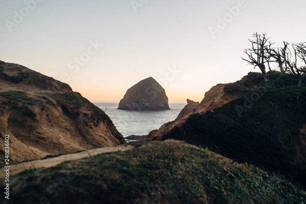 Obraz large rock at beach during sunset