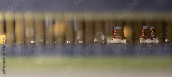 Fototapeta Close up (Macro) of Printed Circuit Board PCB embedded components (inductors, resistors, capacitors, diodes, microchips, transistor) with short depth of view. 