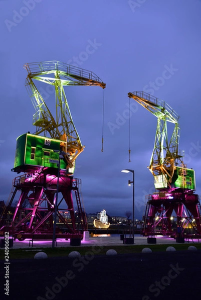 Obraz Colorfully illuminated antique cranes on the quay of Szczecin Łasztownia.