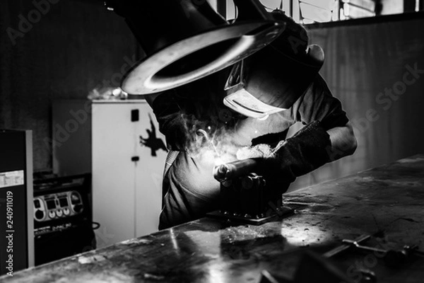 Fototapeta welder worker at work at a metalworking company