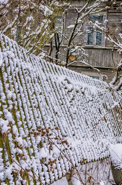 Fototapeta Winter sketches. Fluffy snow on houses, fences and other buildings.