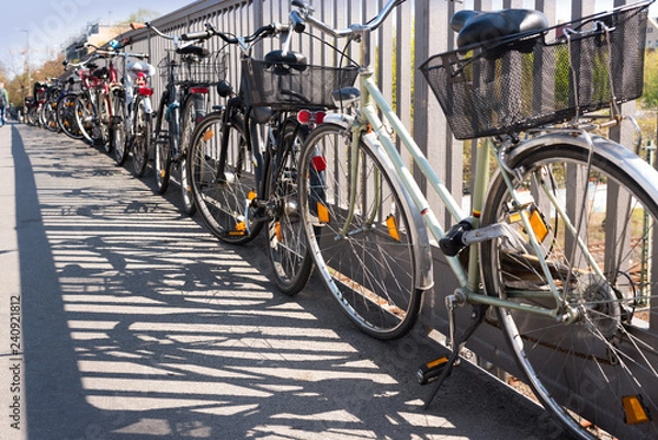 Fototapeta Chaotic bicycle/bike parking in a city - transport, public transport - stolen bikes, old bikes, bike theft - copy space.