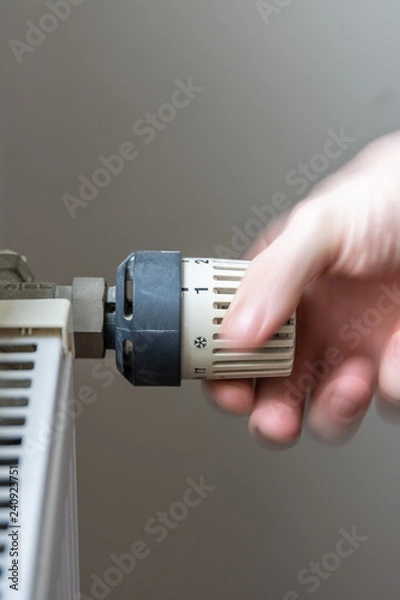 Obraz Male hand changing temperature on radiator