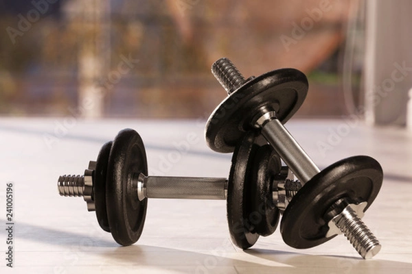 Fototapeta Pair of adjustable dumbbells on floor indoors