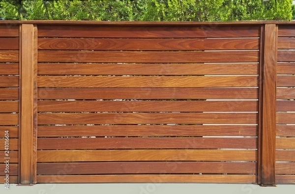 Obraz The fence around the house of wooden planks and wooden pillars, based on a concrete base