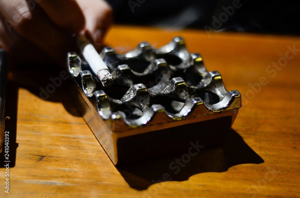 Obraz he takes a cigarette from a traditional ashtray