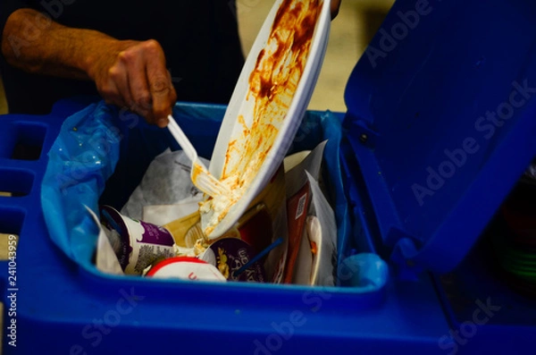 Obraz man pouring food waste into trash