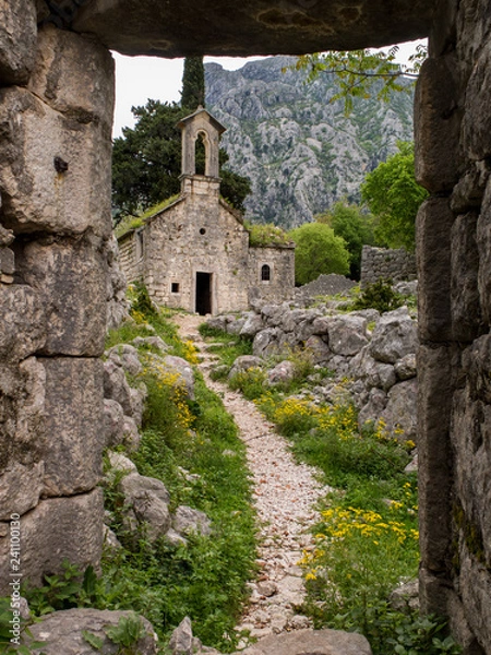 Obraz Path leading to an ancient stone church through a stone gate