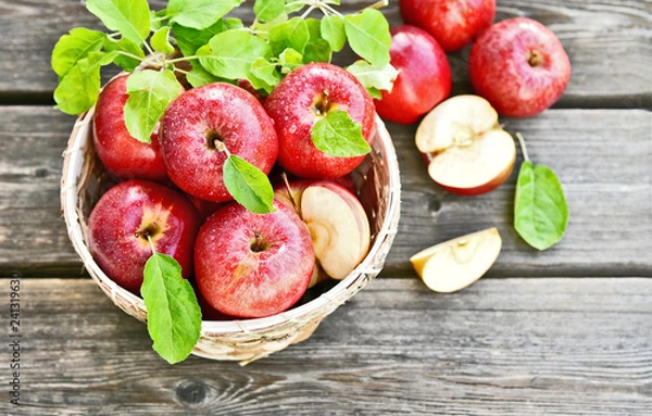 Fototapeta A lot of fresh Royal Red Gala apples with green leaf and water drop in basket on wooden background.