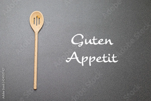 Obraz Holzkochlöffel auf einer Arbeitsplatte neben einem Schriftzug "Guten Appetit"
