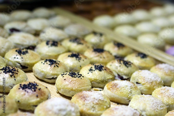 Fototapeta Rows of traditional Chinese cake in oval shape with various nut cream fillings in the box