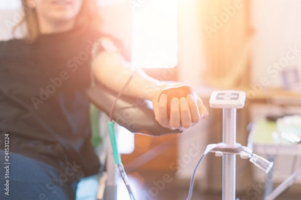 Obraz młoda kobieta jako dawca krwi podczas oddawania z nadmuchiwaną piłką trzyma w ręku