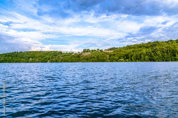Obraz Blue lake water with rippled surface and forest, tranquil scenery
