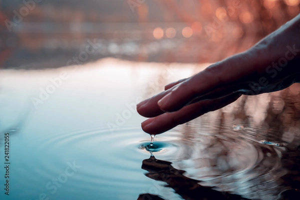 Obraz Finger touches surface of mountain lake. Hand reflection