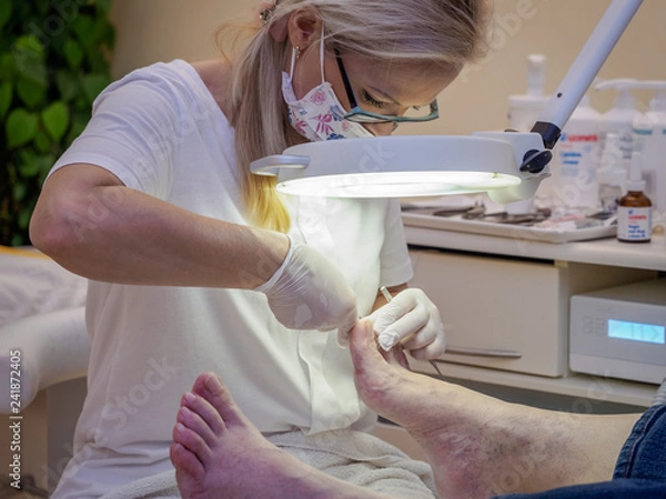 Obraz Female chiropodist working on a senior clients feet.