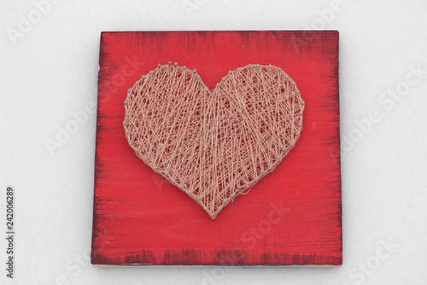 Fototapeta panels of thread and nails, heart on a red background. string art. gift or decoration for February 14 and March 8. with love