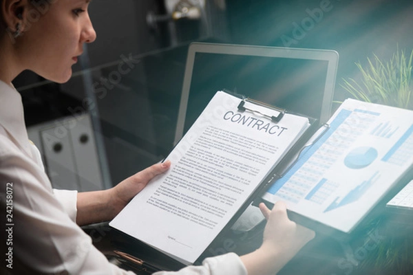 Fototapeta Young girl holding a contract and firm statistics